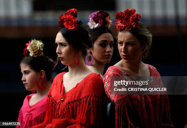 Participants sporting Andalusian traditional dresses wait for parading in the XXXIII "Enganches" exhibition at the Real Maestranza bullring in...