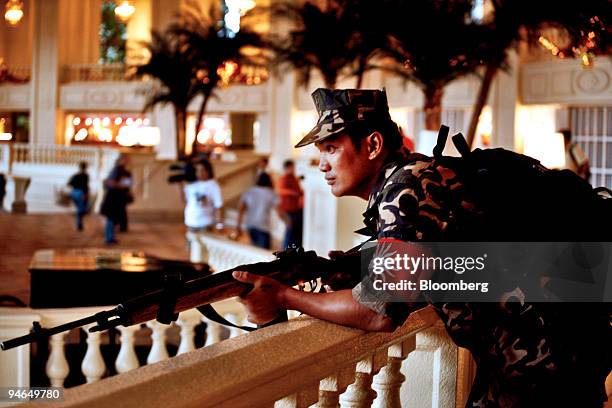 An armed member of the Magdalo group stands guard for Senator Antonio Trillanes and General Danilo Lim inside the Peninsula Hotel in the business...