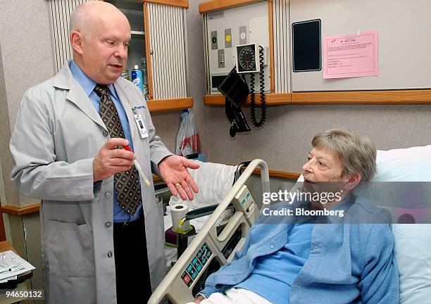 Dr. Lance Peterson explains to patient Mary Minear, at Evanston Hospital in Evanston, Illinois, that he is about to take a nose swab to screen for...