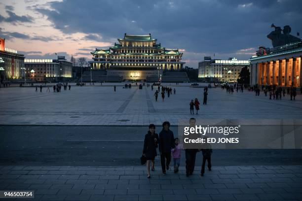 Spectators walk across Kim Il Sung square as they arrive to watch a fireworks display during celebrations marking the anniversary of the birth of...