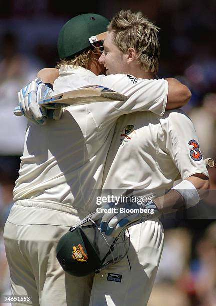 Michael Clarke, right, batting for Australia, is embraced by batting partner Shane Warne after reaching 100 runs on day 4 of the second Ashes Test...