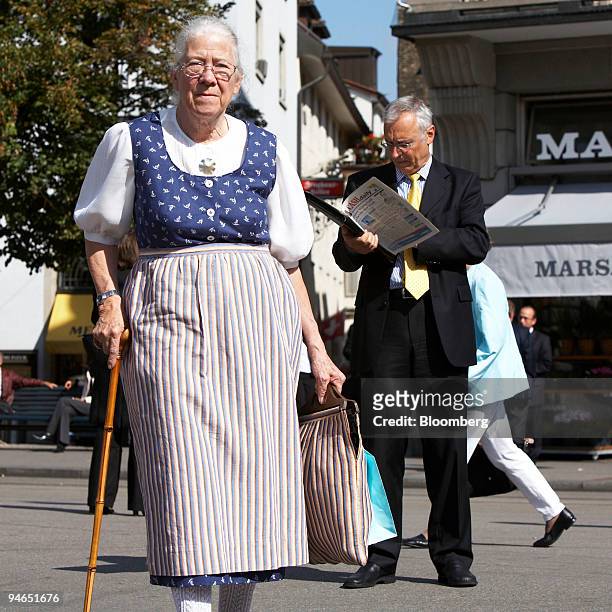 An elderly lady in a traditional Swiss dress walks on the Paradeplatz in Zurich, Switzerland, Wednesday, September 27, 2006.