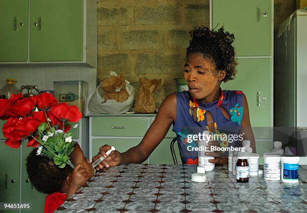 Thandi Mabaso who suffers from AIDS, gives antiretroviral medicine, ARV's, to her daughter Thando Nkosi who also has AIDS, at her homestead near...