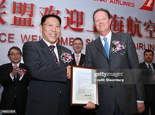 Zhou Chi, chairman of Shanghai Airlines, foreground left, shakes hands with Jaan Albrecht, Star Alliance chief executive officer, during a signing...