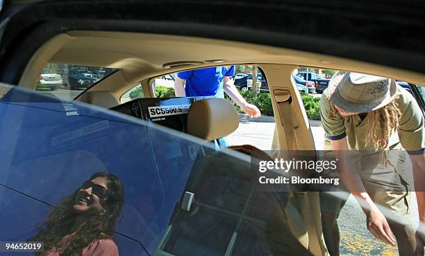 Charlie Worley and Jessica Pelton get help from Devon Tucker loading their new home theatre sound system into their car outside a Westminster,...