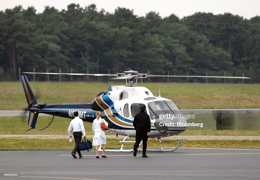 Passengers walk to a helicopter before departing the East Ha