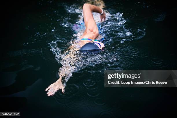 happy confident young female swimmer in an outside pool in southern iceland - swimming free style pool stockfoto's en -beelden