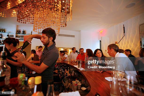 Bartender pours wine for patrons at the bar of Centro I Vinoteca, an Italian bistro in the West Village neighborhood of New York, on Aug. 2, 2007.