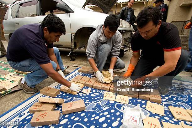 Members of Bolivia's Special Anti-Drug Trafficking Force , label bags of cocaine confiscated from a vehicle in Cochabamba, Bolivia, on Tuesday, Dec....