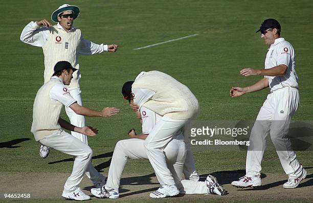 England fielders rush into congratulate bowler Andrew Flintoff, center, after he succeeded in claiming the wicket of Australia's batsman Justin...