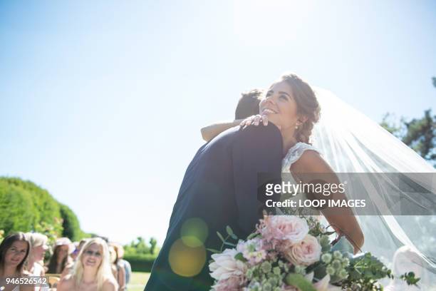 a bride and groom embrace on their wedding day - wedding couple laughing photos et images de collection