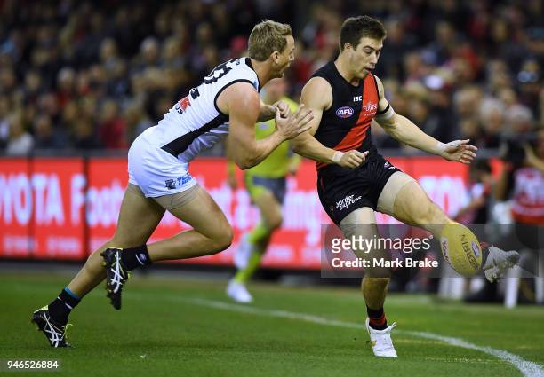 Zach Merrett of the Bombers keeps the ball in play under pressure from Trent McKenzie of Port Adelaide during the round four AFL match between the...