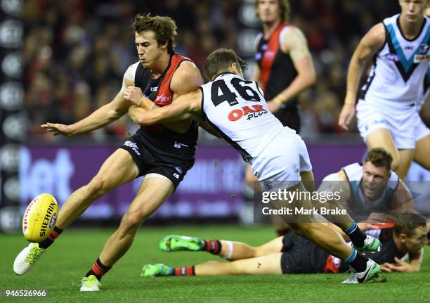 Zach Merrett of the Bombers kicks being tackled by Sam Gray of Port Adelaide during the round four AFL match between the Essendon Bombers and the...
