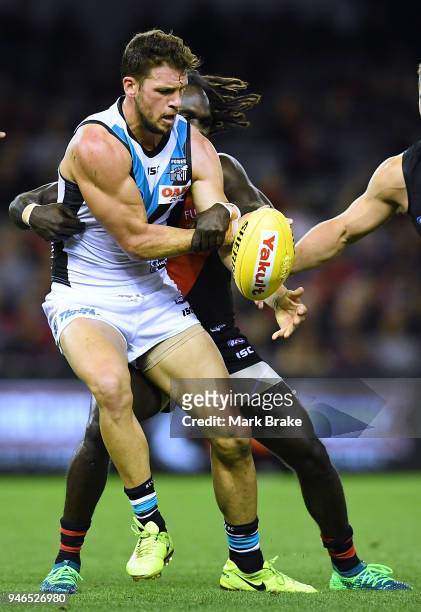 Travis Boak captain of Port Adelaide tackled by Anthony McDonald-Tipungwuti of the Bombers during the round four AFL match between the Essendon...