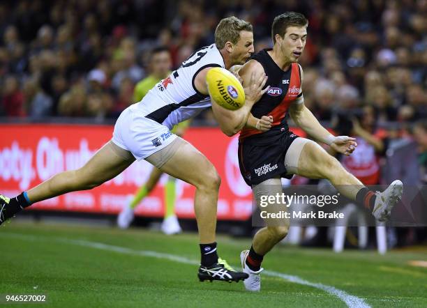 Zach Merrett of the Bombers keeps the ball in play under pressure from Trent McKenzie of Port Adelaide during the round four AFL match between the...