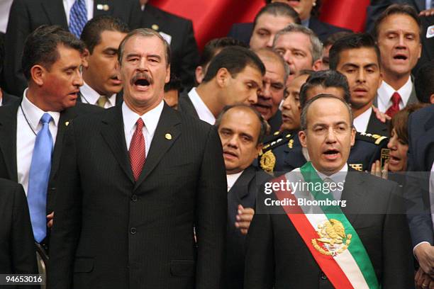 Former Mexican President Vicente Fox, left, and Mexican President Felipe Calderon sing during Calderon?s inauguration with former President Vicente...