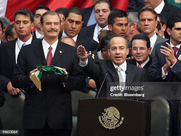 Mexican President Felipe Calderon, right, takes the oath of office with former President Vicente Fox, left, at Mexico's Congress in Mexico City,...