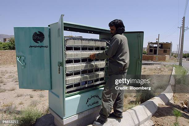 Reza Fazeli, a telephone engineer, works on a switchbox in the Baz e Nader section of Natanz, Iran, on Monday, July 24, 2006. Fazeli said he...