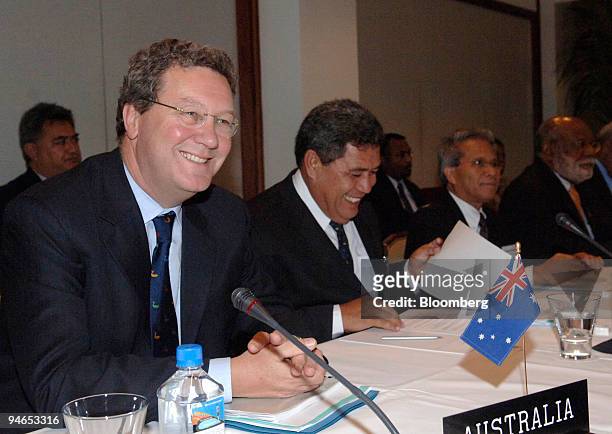Alexander Downer, Australia's minister of foreign affairs, left, smiles at the start of a meeting of foreign ministers from the Pacific Islands...