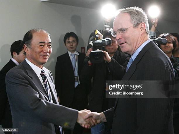 Christopher Hill, U.S. Assistant secretary of state, right, shakes hands with Kenichiro Sasae, bureau chief of Japanese Foreign Ministry's Asian and...