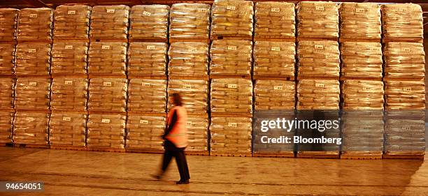 Worker walks past bags of powdered milk at the Rapa Fonterra factory in Hamilton, New Zealand, on Monday, July 24, 2006. New Zealand's annual trade...
