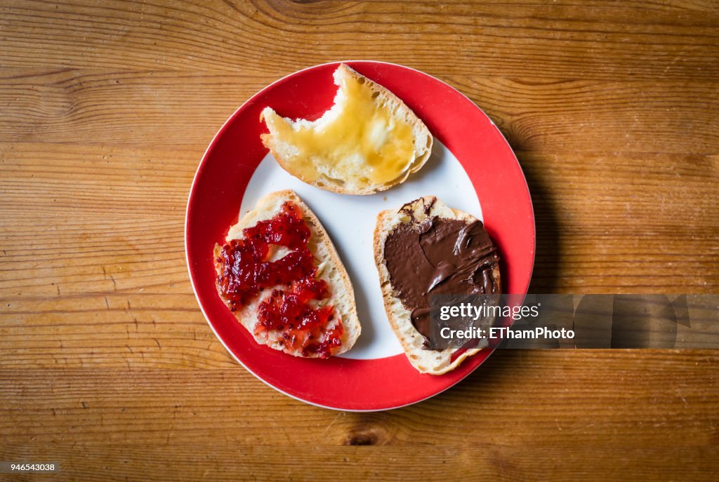 Healthy breakfast with slices of bread with marmalade, honey and hazelnut spread