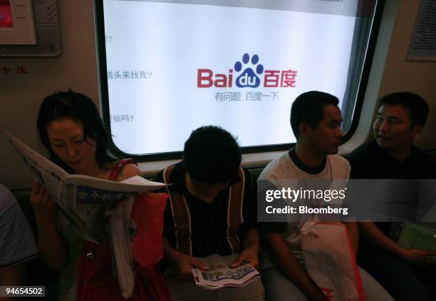Baidu.com Inc. Advertisement is seen behind passengers on a metro train in Shanghai, China, on Friday, July 21, 2006. For Baidu.com Inc., the Google...