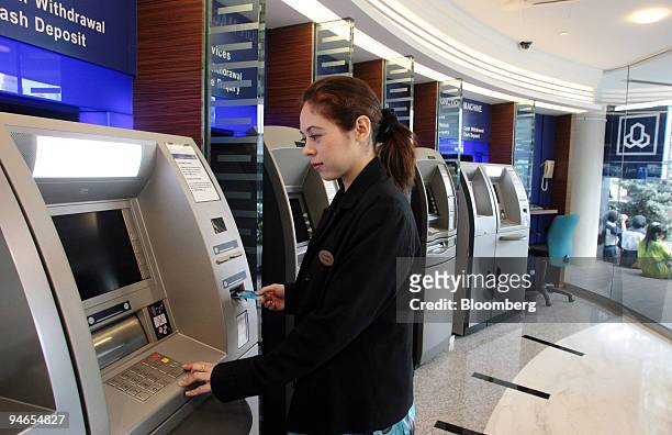 Customer relations officer demonstrates how to use an ATM at the Al Rajhi Bank in Kuala Lumpur, Malaysia, on Monday, Feb. 5, 2007.