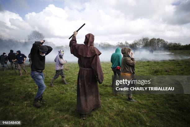 Protester dressed as a monk gestures as protesters, trying to gain access to rebuild squats, clash with anti-riot gendarmes at the ZAD decade-old...