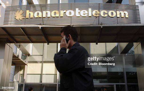 An employee walks past a sign for Hanarotelecom Inc. At the company's branch office in Ilsan, South Korea, on Monday, Dec. 3, 2007. SK Telecom Co.,...