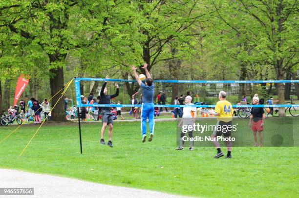 Some people play volley on a cloudy spring day in Munich.