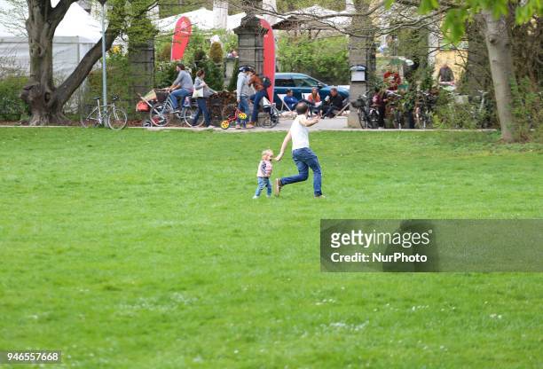 Dad plays with his child on a cloudy spring day in Munich.