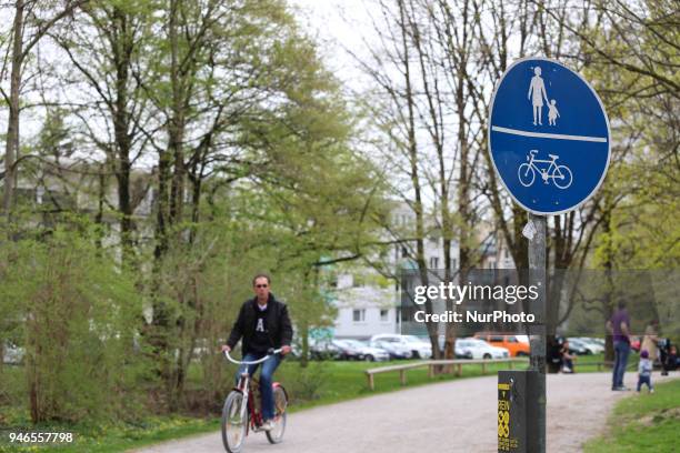 Man rides his bike in the Luitpoldpark on a cloudy spring day in Munich.