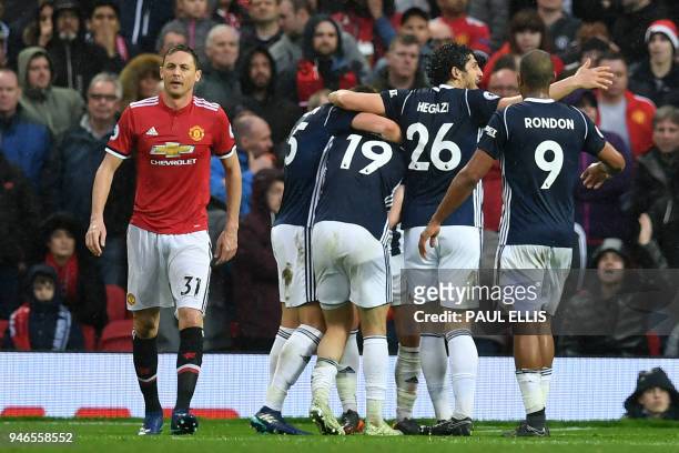 Manchester United's Serbian midfielder Nemanja Matic who's error led to the goal, reacts as West Brom players celebrate their opening goal during the...