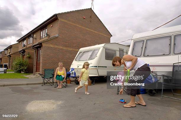 June Willey, left, watches Nicola Caster, right, as she plays with her daughter Holly outside their caravan on California Drive, in Catcliffe,...