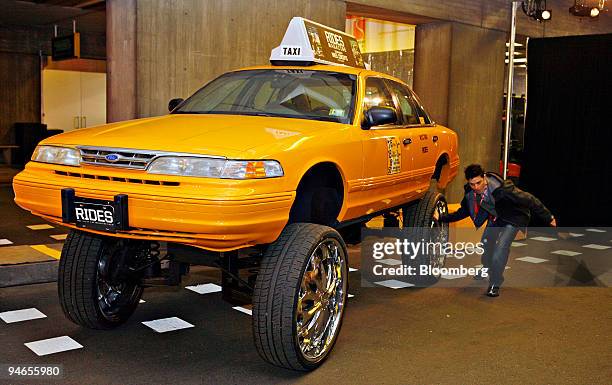 Brandon Himmel, publicist for Rides Magazine, spins the wheel of Crown Vic Hi-Riser Taxi at the TAXI 07 Exhibit at the New York International Auto...