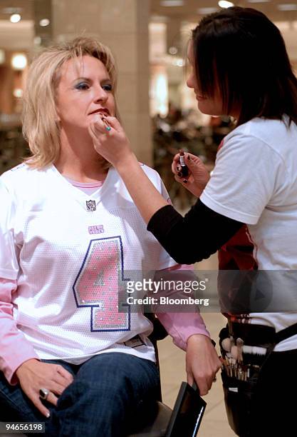 Sue Boor of Indianapolis, wearing a pink jersey of Indianapolis Colts kicker Adam Vinateri, has make-up applied at department store near the RCA...