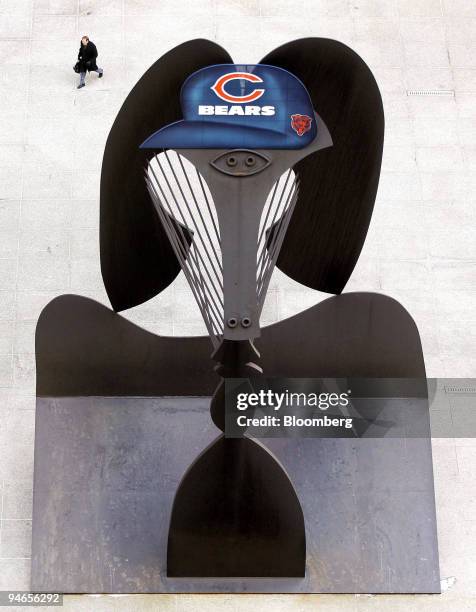 Man walks near a Picasso art sculpture, which has been fitted with a Chicago Bears cap, in Daley Plaza in Chicago, Illinois, Friday, Feb. 2, 2007....