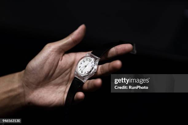 close up of mans hand holding wristwatch - wristwatch stockfoto's en -beelden