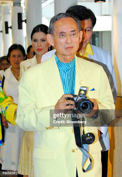 Thai King Bhumibol Adulyadej holds a camera as he walks into Siriraj hospital in Bangkok, Thailand, Thursday, July 20, 2006. King Bhumibol will...