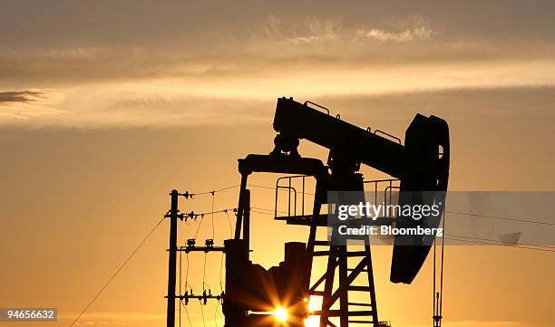 Nodding donkey" oil pump pumps oil at sunset in an oilfield outside Daqing, Heilongjiang province, China, on July 13, 2006. PetroChina Co., the...