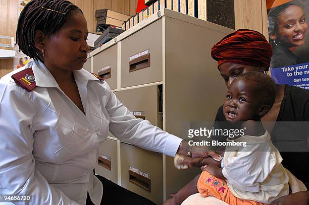 Nurse Zonke Dlalisa applies medicine to the skin of a child who has lesions caused by AIDS at an HIV/AIDS clinic in the rural Emmaus Hospital, 20km...