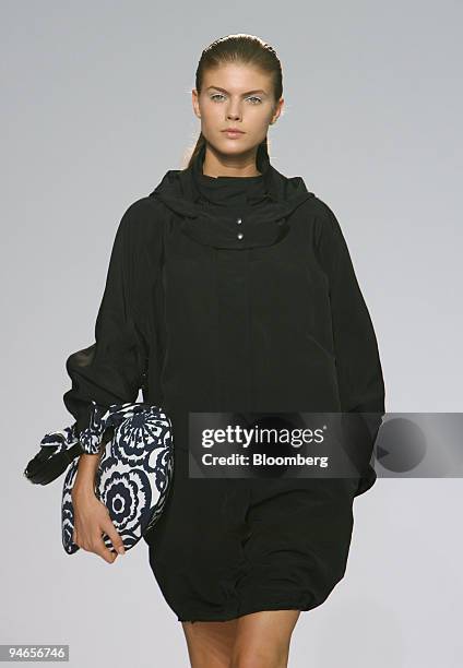 Model walks down the catwalk wearing a black parka and carrying a navy rosette print pouch during the showing of fashion designer Nicole Farhi's 2007...
