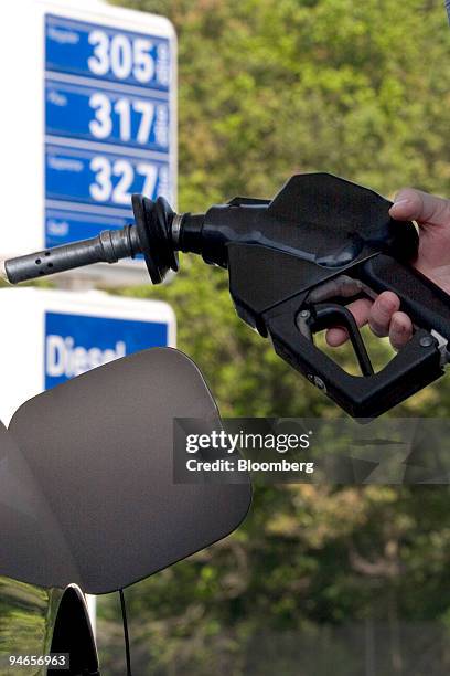 Customer pumps gasoline at an Exxon station on the Massachusetts Turnpike outside Framingham, Massachusetts, Friday, July 14, 2006. Gasoline futures...