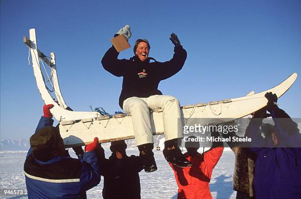Annika Ostberg of Denmark holds the trophy as she's lifted atop a traditional dogsledge after victory in the Drambuie World Ice Golf Championships in...