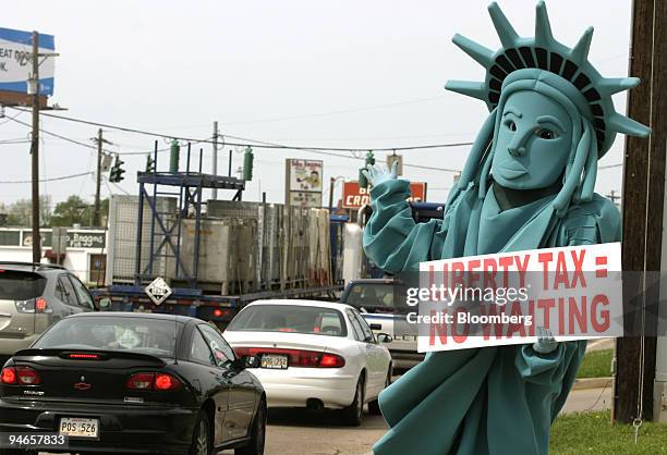 Ben Combs waves to lunchtime drivers in his Statue of Liberty costume while working for the Liberty Tax Service in Bossier City, Louisiana, on...