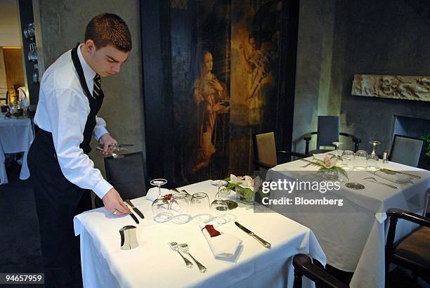 Server Hubert Deneux lays on the tables at the Il Settimo restaurant in Paris, France, Thursday, Feb. 1, 2007.