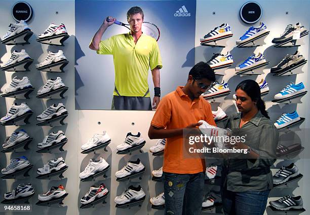 Man and a woman look at sneakers manufactured by Adidas at a mall in Mumbai, India, on Thursday, Nov. 29, 2007. India's economy grew last quarter at...