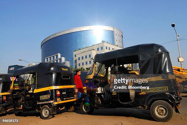 Three-wheeled auto-rickshaws are parked near the IL&FS building, one of India's leading infrastructure-development and finance companies, in Mumbai,...