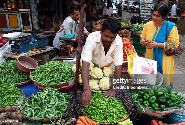 Woman purchases vegetables at a traditional vegetable market in Mumbai, India, on Thursday, Nov. 29, 2007. India's economy grew last quarter at the...